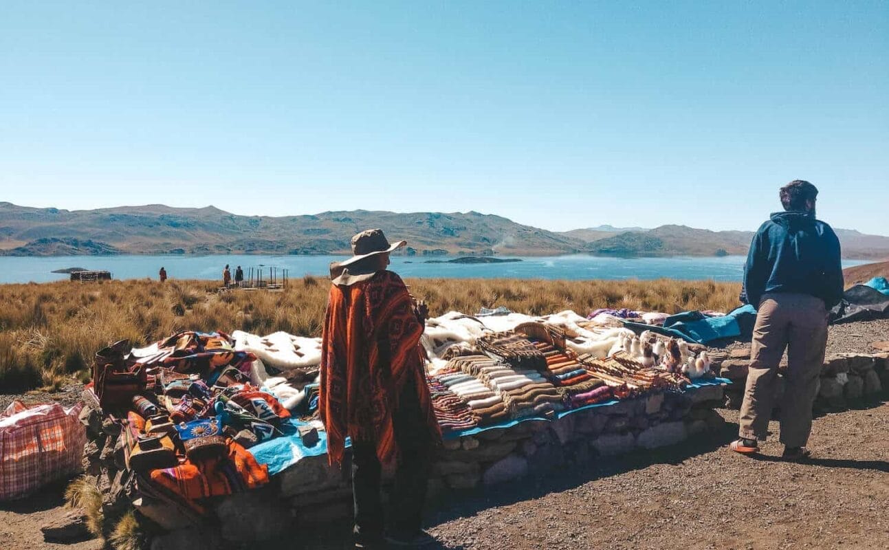 Vendor selling sweaters in Andes Mountains, Peruvian lagoon