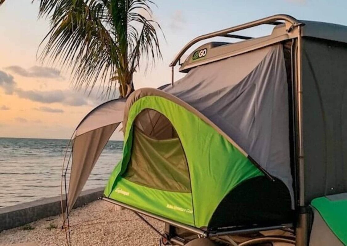 sunset view with palm tree, water, and a pop up camper in Marathon Florida Keys