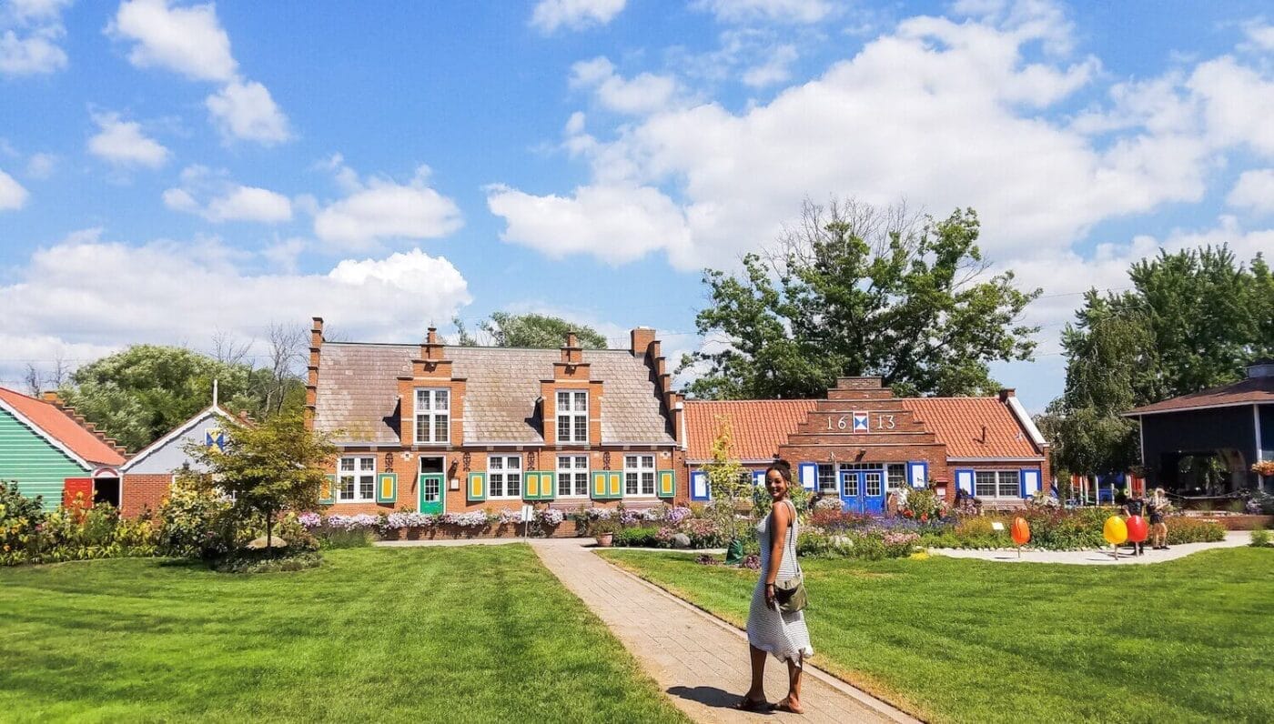 Woman at the Windmill Island Gardens with Dutch houses and tulips