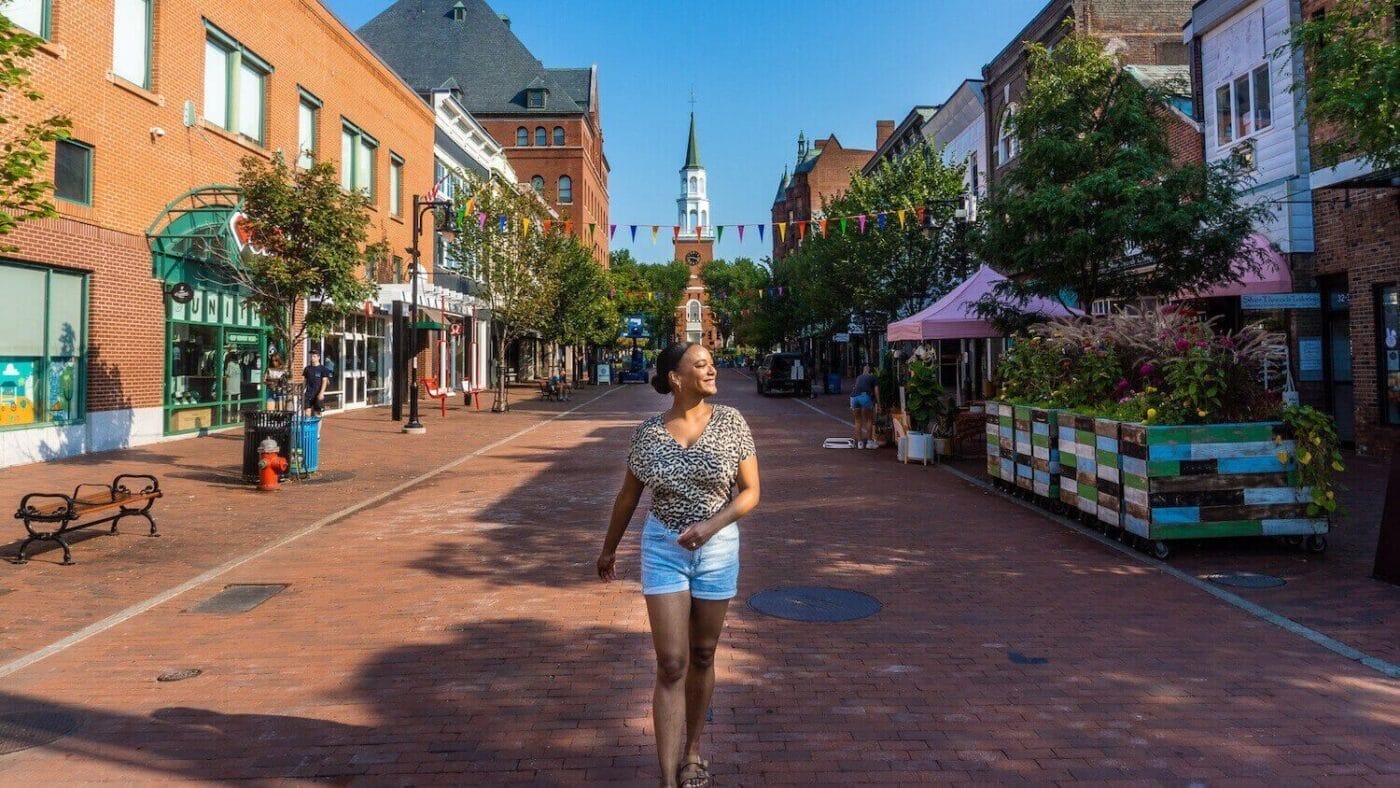 Walking through red brick pedestrian street with church in the background and farmers market