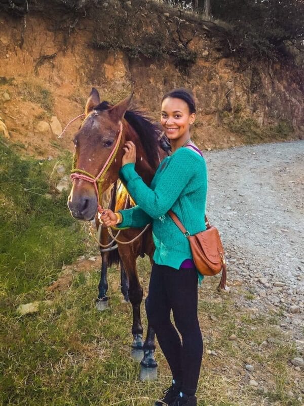 Black girl with a horse in the mountains