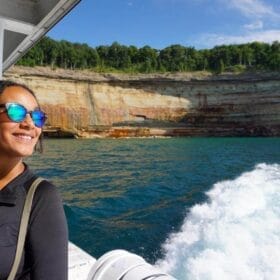 Woman on a lake superior cruise next to sandstone cliffs