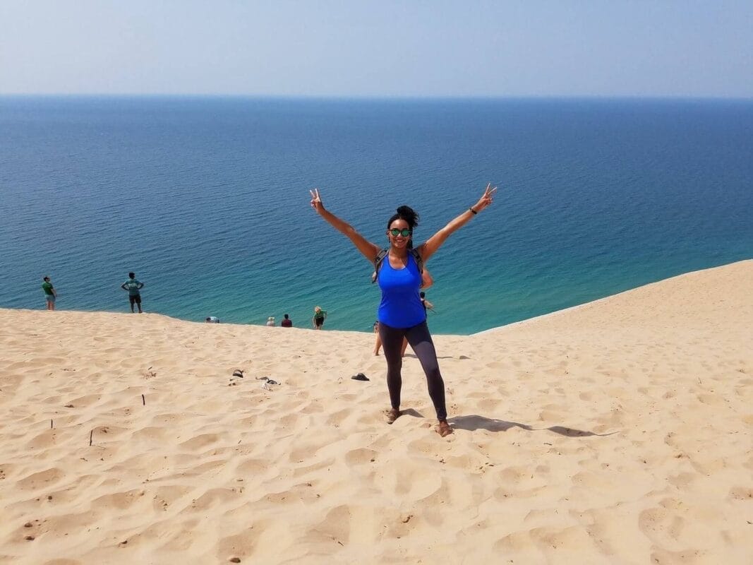 Standing at the top of a tall dune over a clear lake