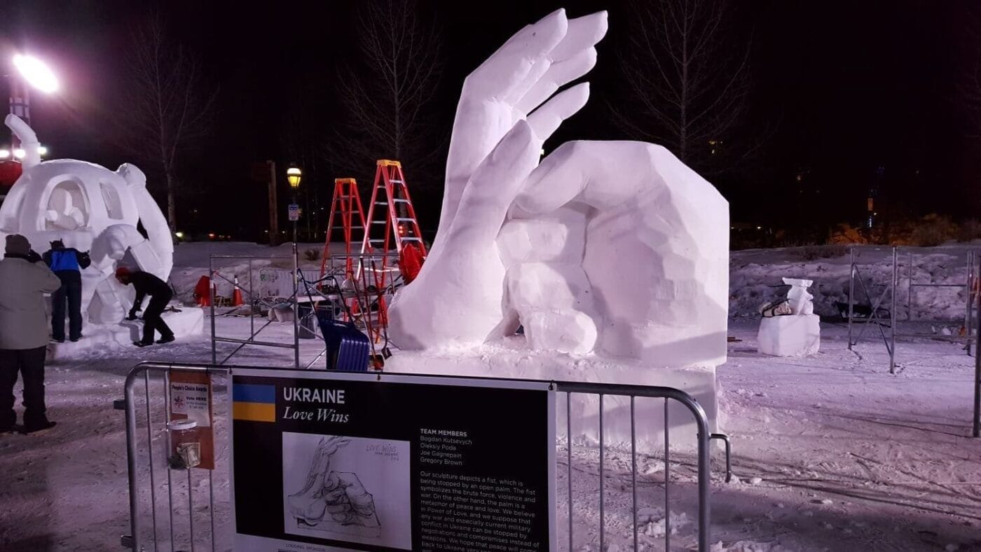 Ice sculpture of large hands with a sign that says "Love Wins"