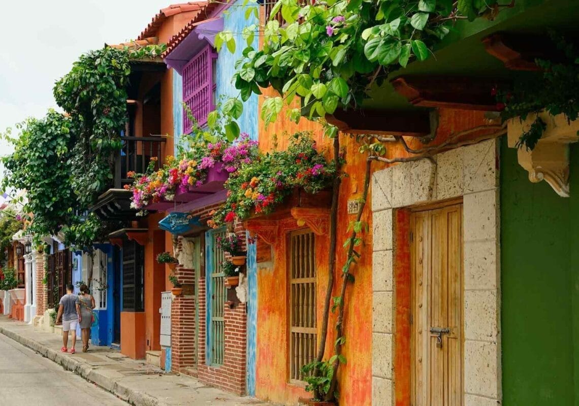 colorful homes with small balconies and lush green vines