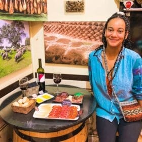 olivia eating jamon charcuterie platter in restaurant surrounded by ham