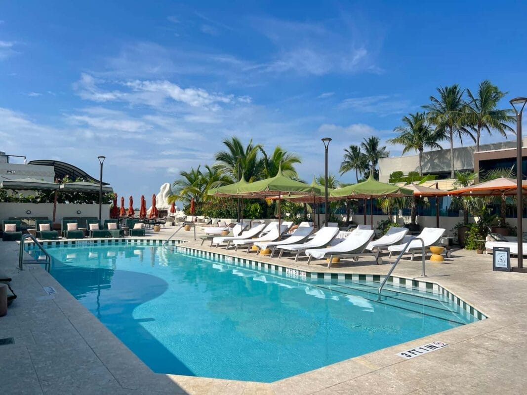 Rooftop pool with beach chairs and umbrellas