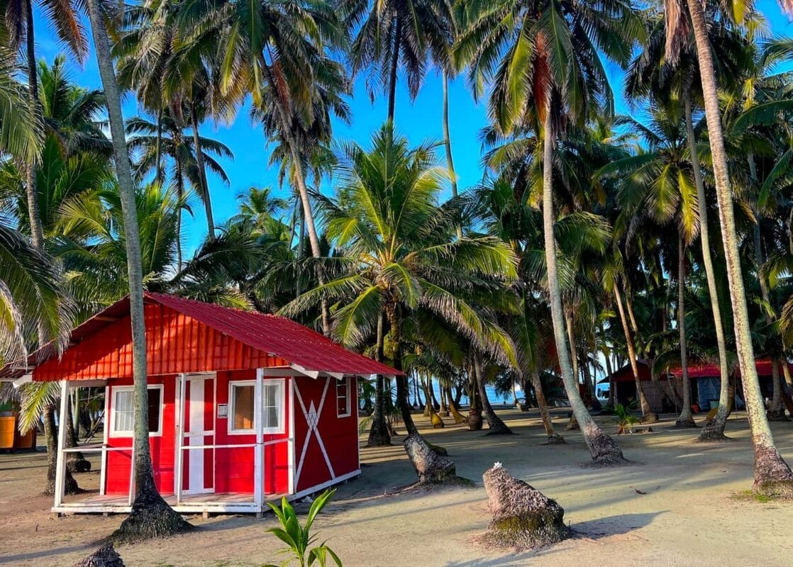 bright red cabin on secluded island with palm trees