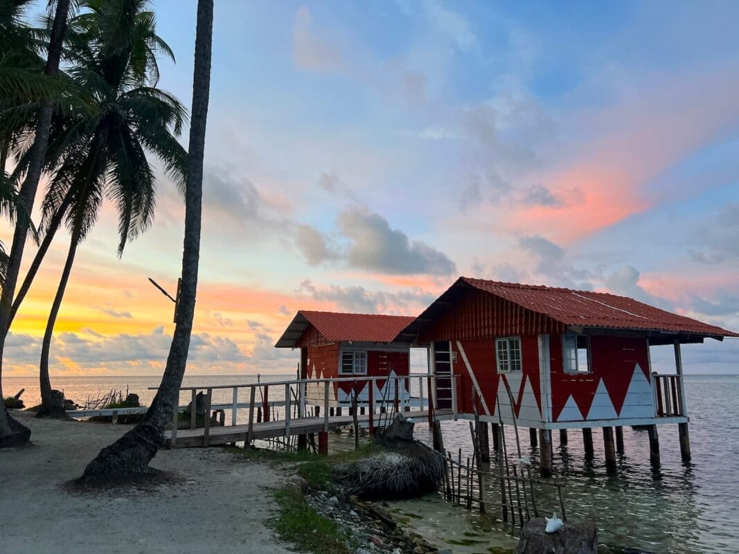 Sunset view of two overwater bungalows on the island