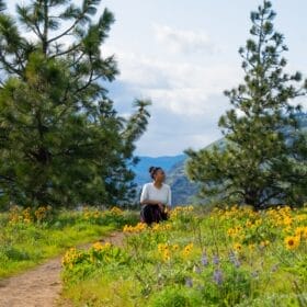 Olivia smelling the flowers on a hike